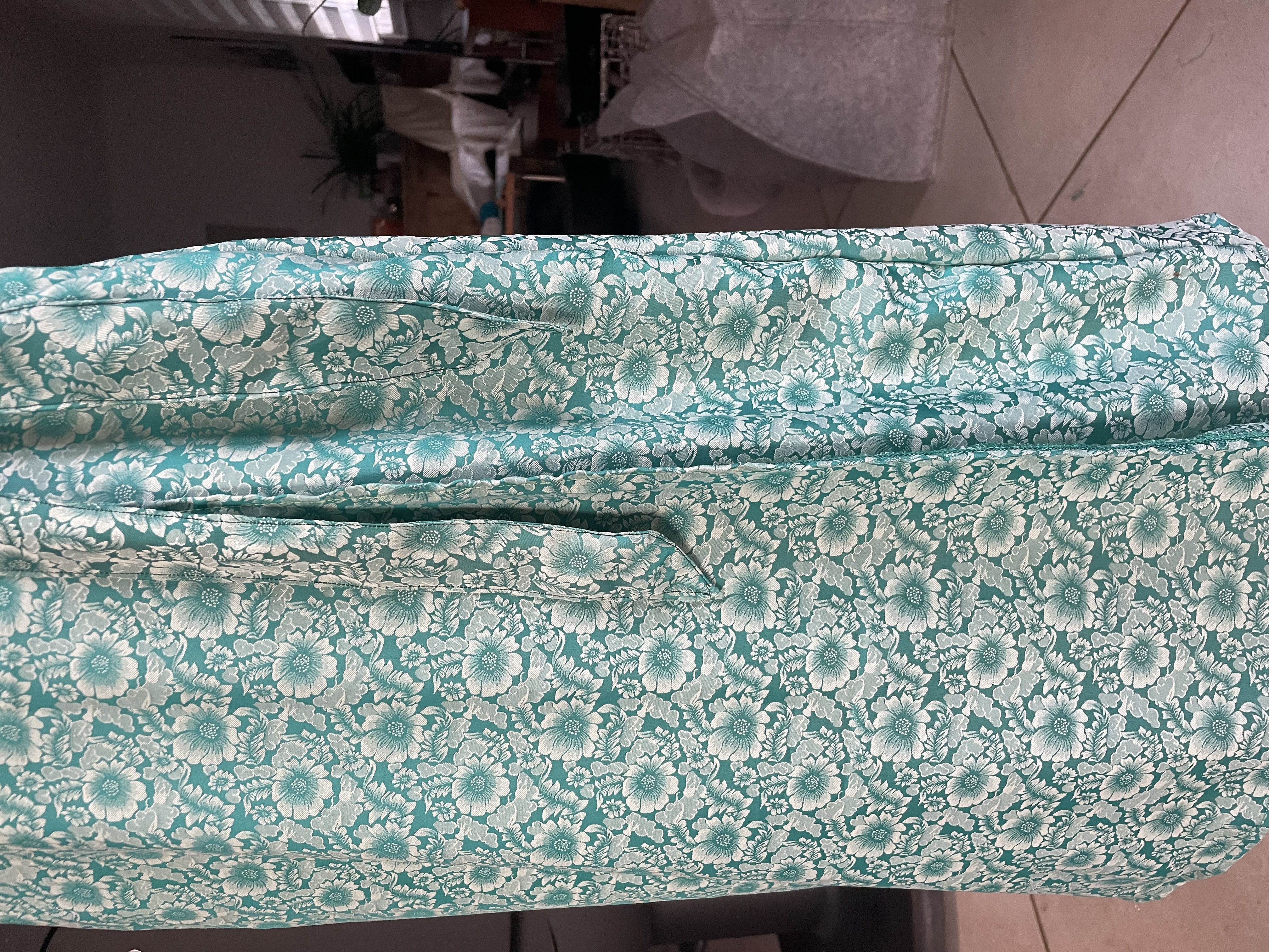 Vue de la soie turquoise fleurie utilisée pour la robe portefeuille