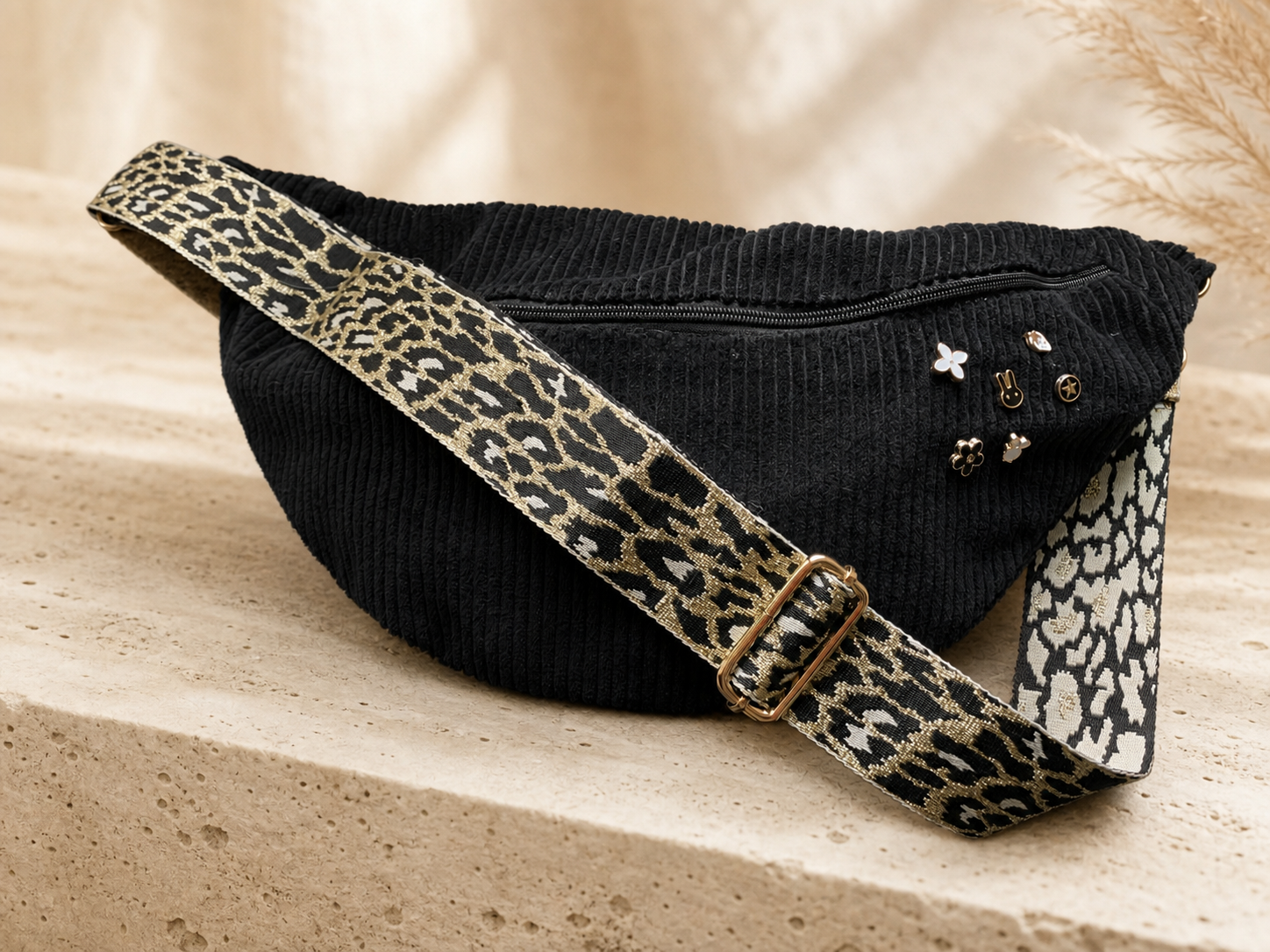 Sac banane velours noir dans un décor studio chaleureux